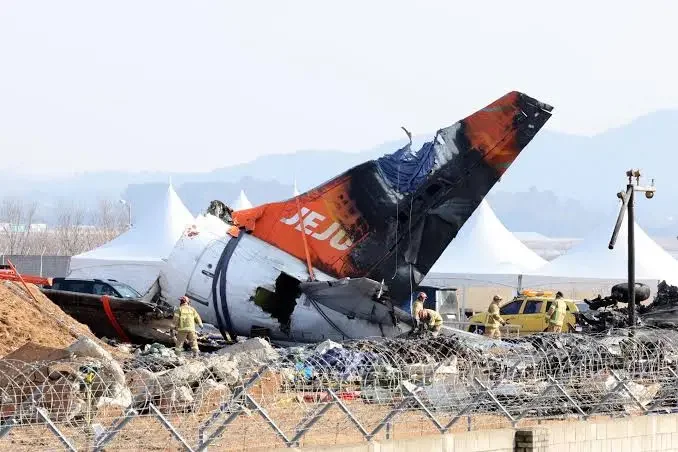 Firefighters remove tarpaulin sheets covering the debris of a Jeju Air passenger plane at Muan International Airport in Muan, southwestern South Korea, 13 January 2025, following its crash on 29 December 2024. EFE-EPA/YONHAP/FILE